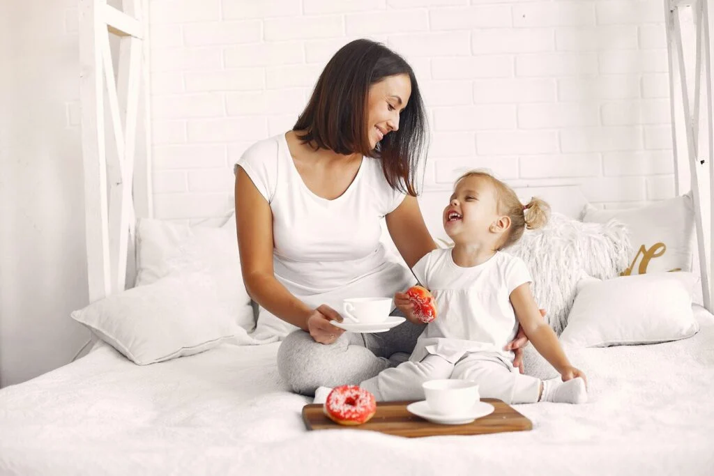 Une maman et sa petite fille prennent le petit déjeuner à la maison