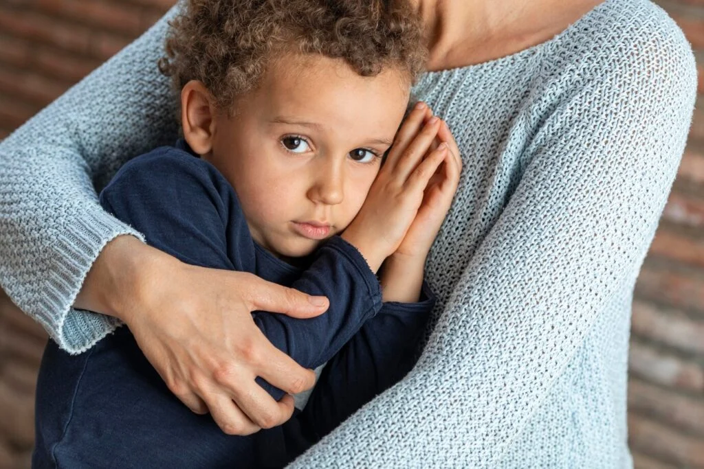 Petit garçon triste réconforté par sa maman