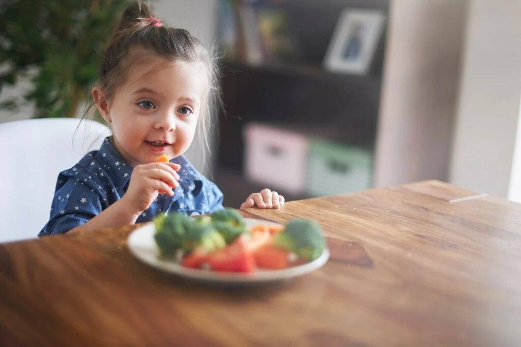 Petite fille qui mange des légumes